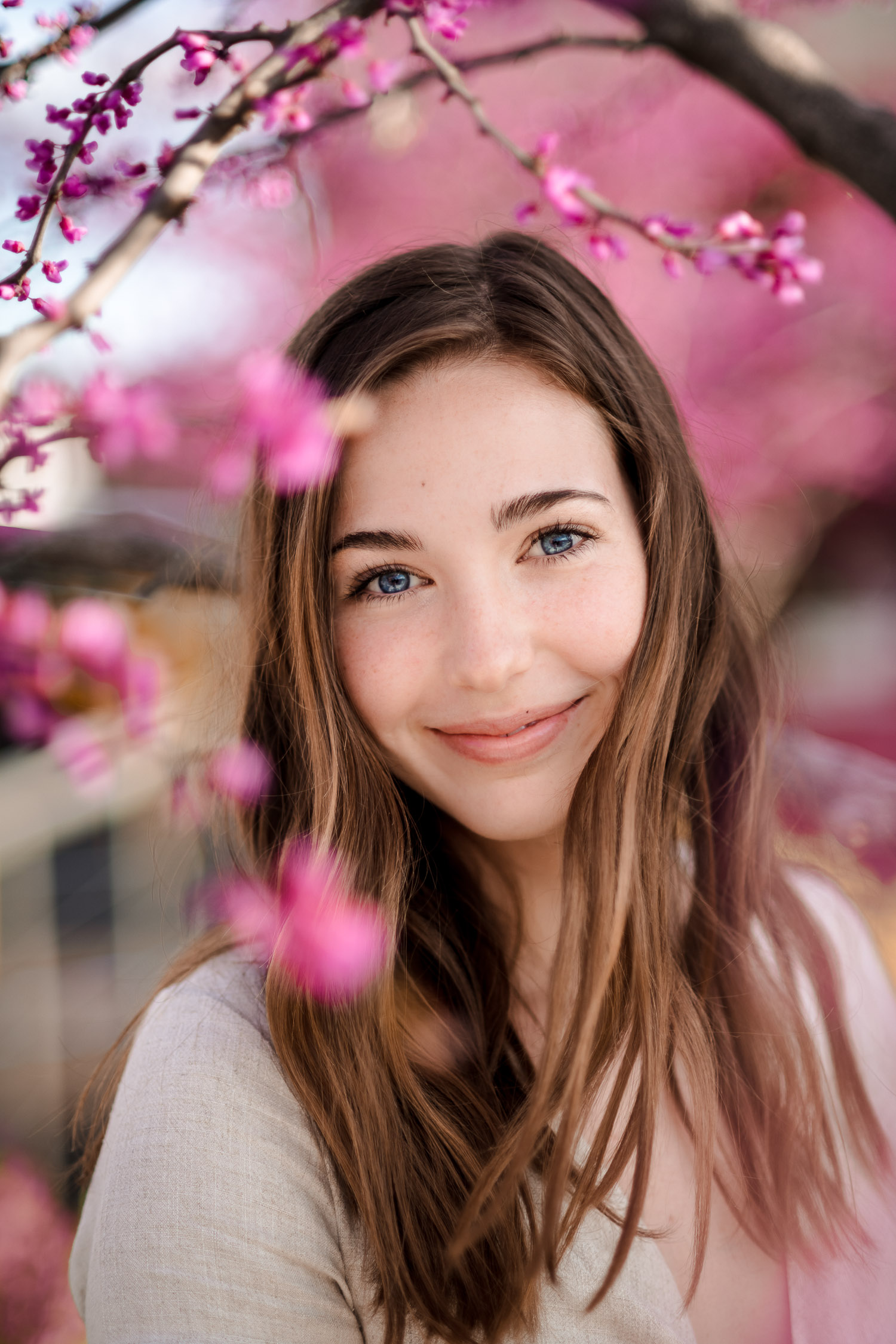 Senior portrait girl smiling with pink Redbud flowers