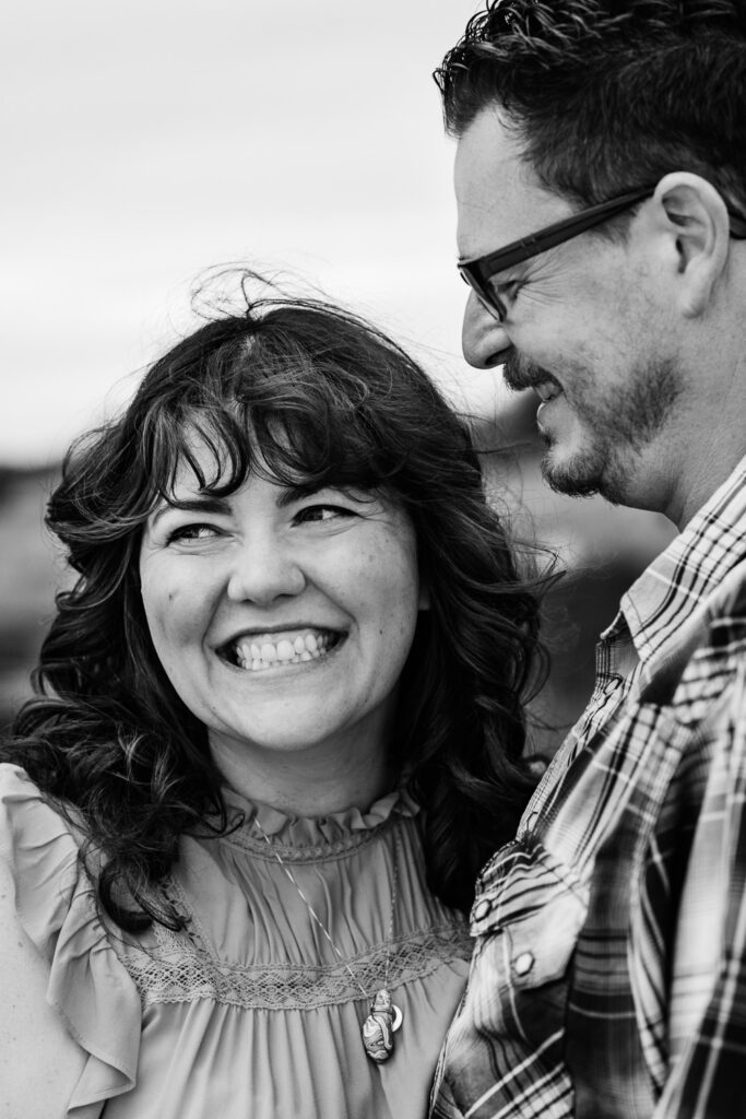 Brunette woman smiles as fiance looks at her