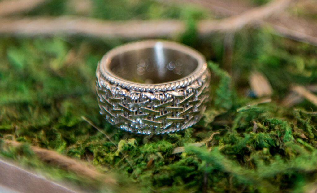 braided wedding band sitting in moss.