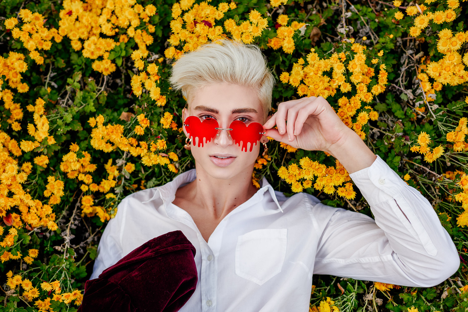 Senior Zachary Willmore Red Heart Glasses laying in yellow flowers