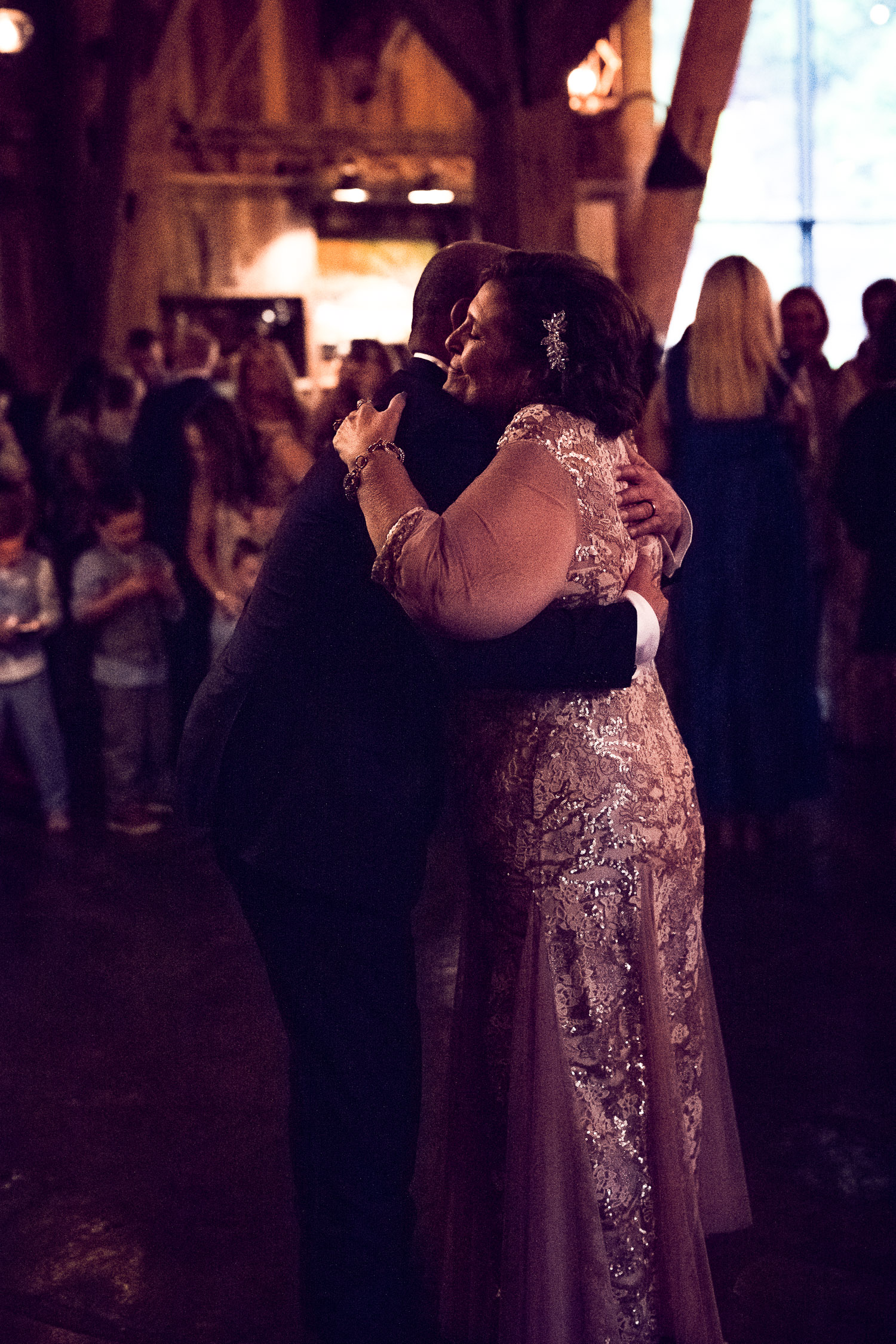 Groom hugs mother after mother son dance