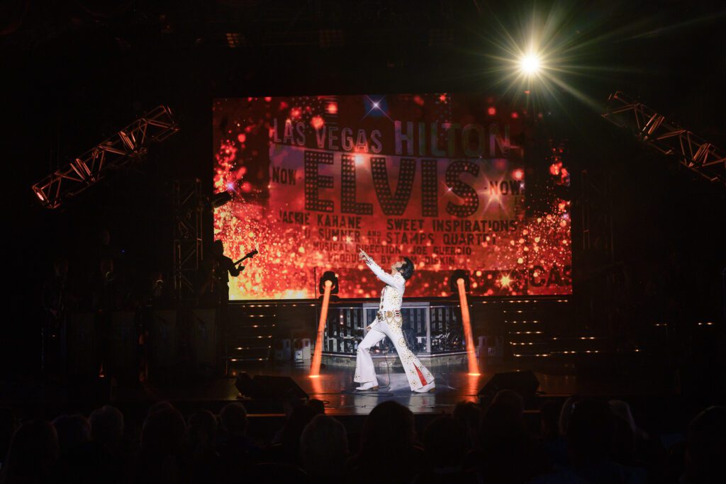 Dean Z performing as Elvis Presley in White Jumpsuit on stage in Branson.