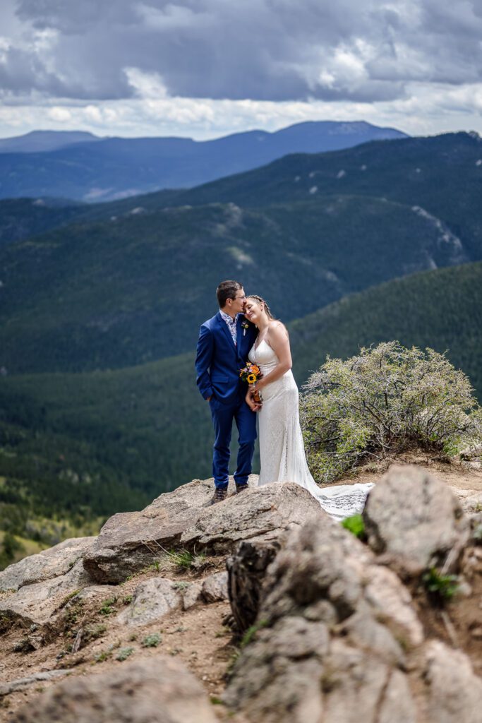 bride and groom stand in front of colorado mountains near idaho springs colorado