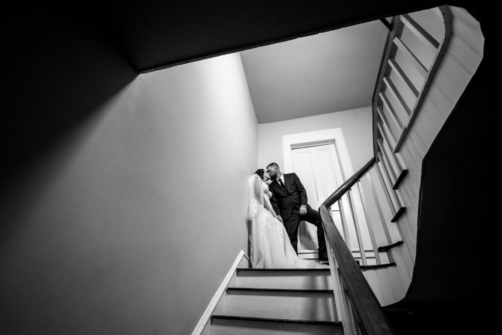 bride and groom kiss in stairwell