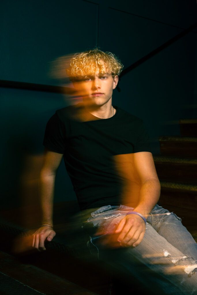 Senior guy with creative motion blur portrait orange and blue light
