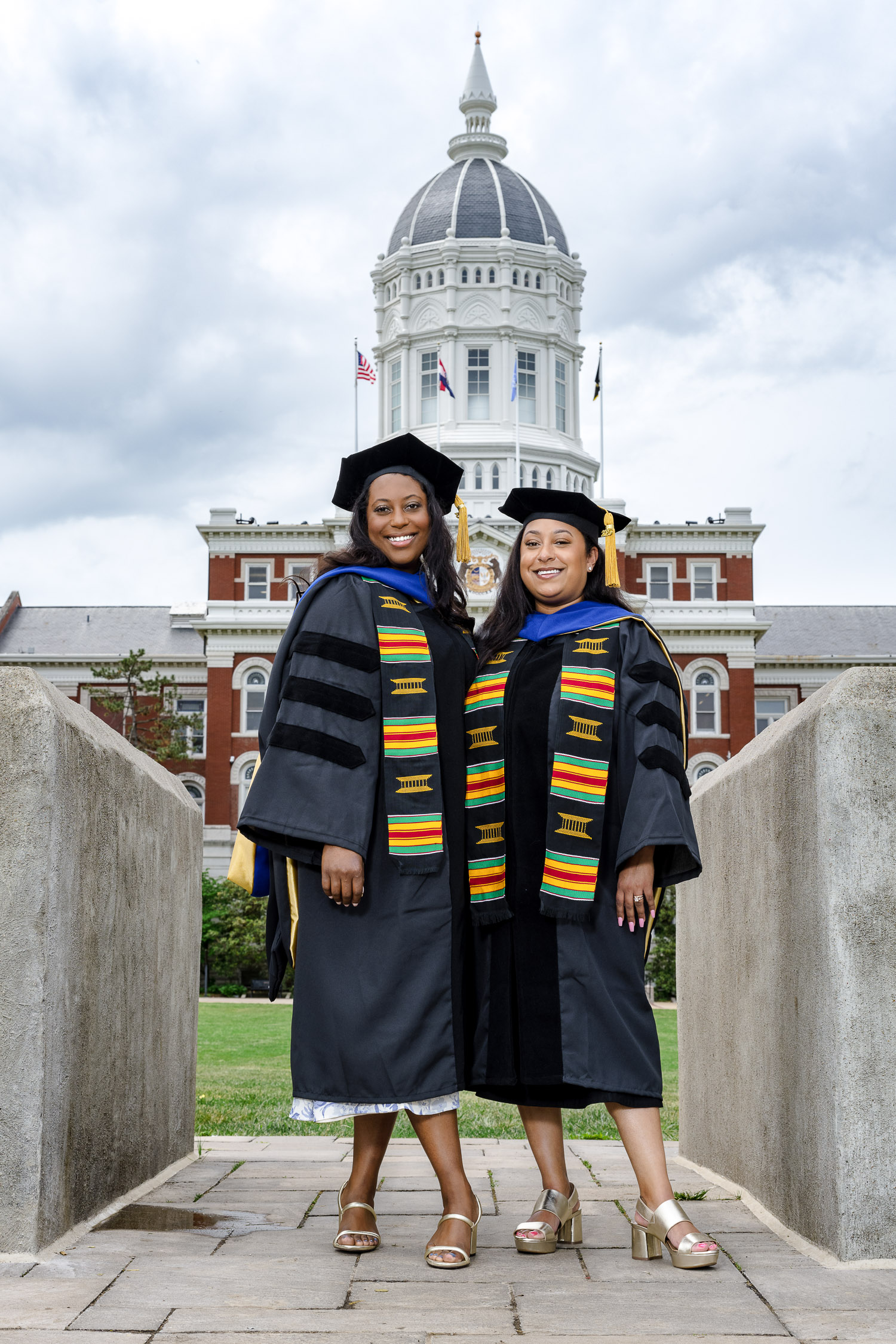 Graduate Seniors wearing cap and gowns and kente stole with jesse hall